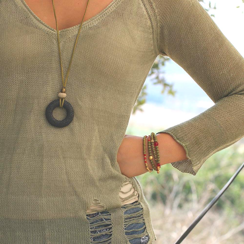 Earthy statement necklace with a bold black lava bead and soft green suede leather cord, highlighting natural texture and artisan design.