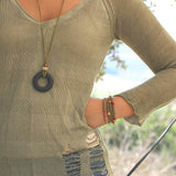 Earthy statement necklace with a bold black lava bead and soft green suede leather cord, highlighting natural texture and artisan design.