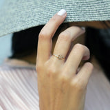 Elegant portrait of model wearing a handcrafted silver circle ring with geometric cut-out details. The soft satin finish and slender band create a clean, modern aesthetic inspired by natural balance.