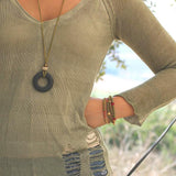 Earthy statement necklace with a bold black lava bead and soft green suede leather cord, highlighting natural texture and artisan design.