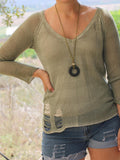 Statement jewelry piece with a black volcanic stone pendant on olive green suede, shown in natural lighting to emphasize materials and craftsmanship.