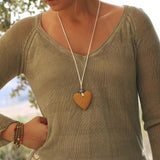 Long suede cord necklace featuring a textured yellow lava stone heart and smooth graphic bead, perfect for bold, handmade jewelry lovers.