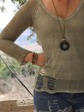 Organic-style handmade necklace with a black lava pendant and soft olive green suede cord, photographed for texture and contrast.