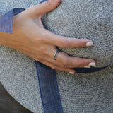 Oxidized silver ring worn on a woman’s hand, emphasizing its bold modern style