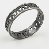 Close-up of the dark silver openwork ring highlighting the oxidized finish and geometric texture