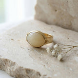 Front-facing view of the gold statement ring displaying the oval yellow gemstone and artisan finish.