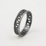 Oxidized silver geometric ring for women on a white background, showing the dark openwork band