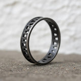 Dark geometric silver ring standing upright to display the open design and artisan finish.