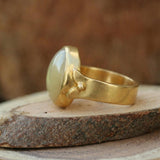 Natural yellow calcite ring styled on a warm wooden surface, emphasizing its golden tones and bold presence.